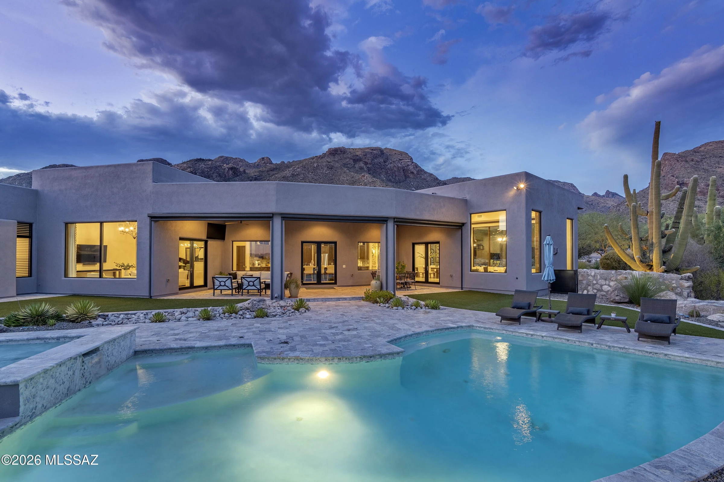 Kevin B Howard's Pima Village Court residence, with illuminated living spaces opening to the desert and pool